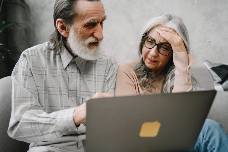 Man Explaining Things From Laptop To Woman Looking Confused 