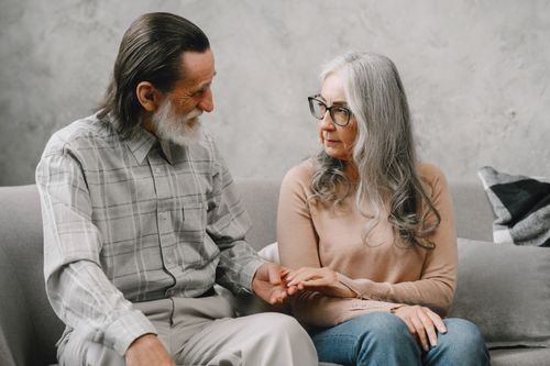 Free Elderly couple sitting on a sofa, conveying warmth and togetherness. Stock Photo