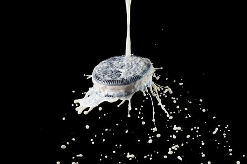 Free Dynamic image of milk splashing onto a chocolate cookie against a black background. Stock Photo