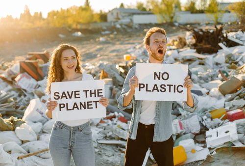 Free Two activists holding signs at landfill to protest plastic pollution. Stock Photo