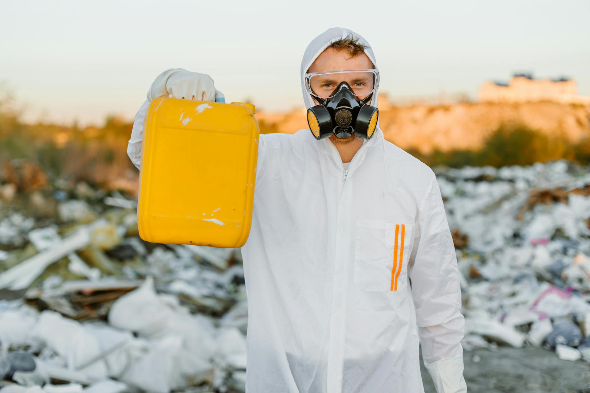 Person in PPE holding Yellow Gallon