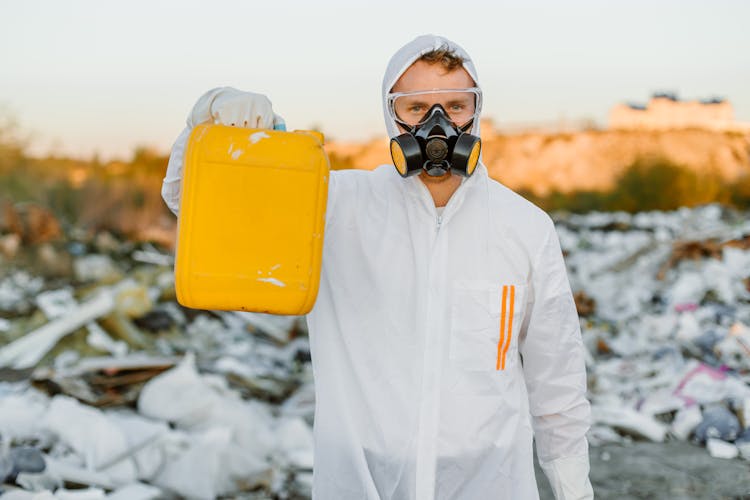 Person In PPE Holding Yellow Gallon