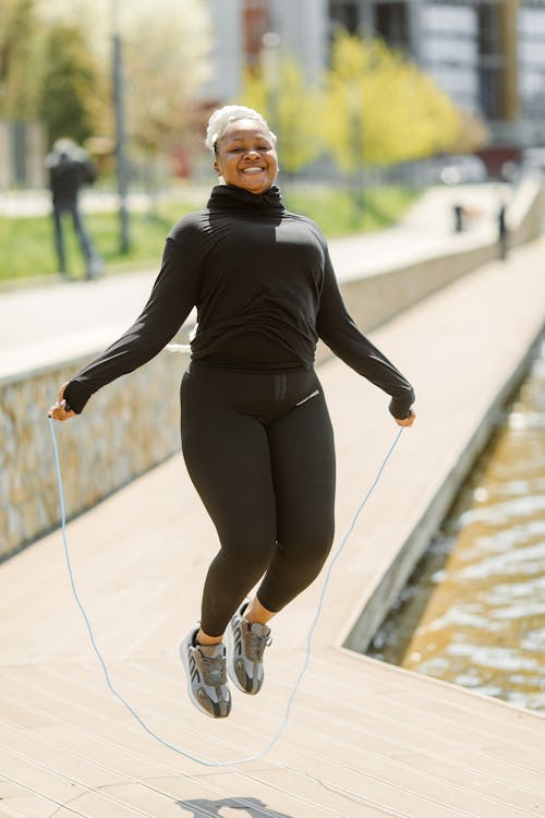 Woman in Black Active Wear using Jumping Rope 