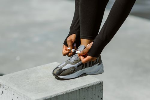 Free Focused photograph of hands tying athletic shoe laces outdoors, highlighting active lifestyle. Stock Photo