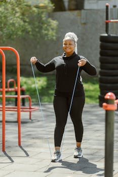 Woman enjoying a healthy lifestyle with jump rope exercise in outdoor park.