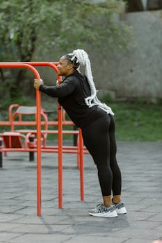 Woman in activewear performing push-ups on outdoor fitness bars.