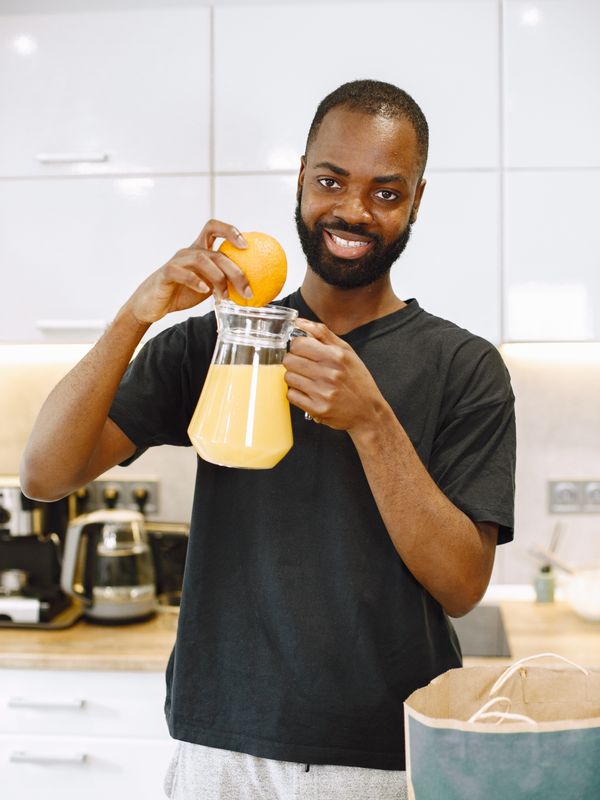 A man pouring fresh juice in his kitchen in the morning — photo by Gustavo Fring on Pexels