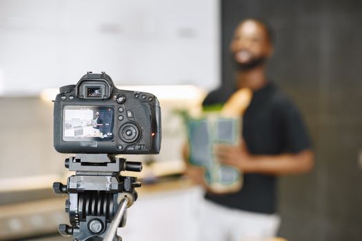A DSLR camera capturing a man in a kitchen, perfect for food blogging content.