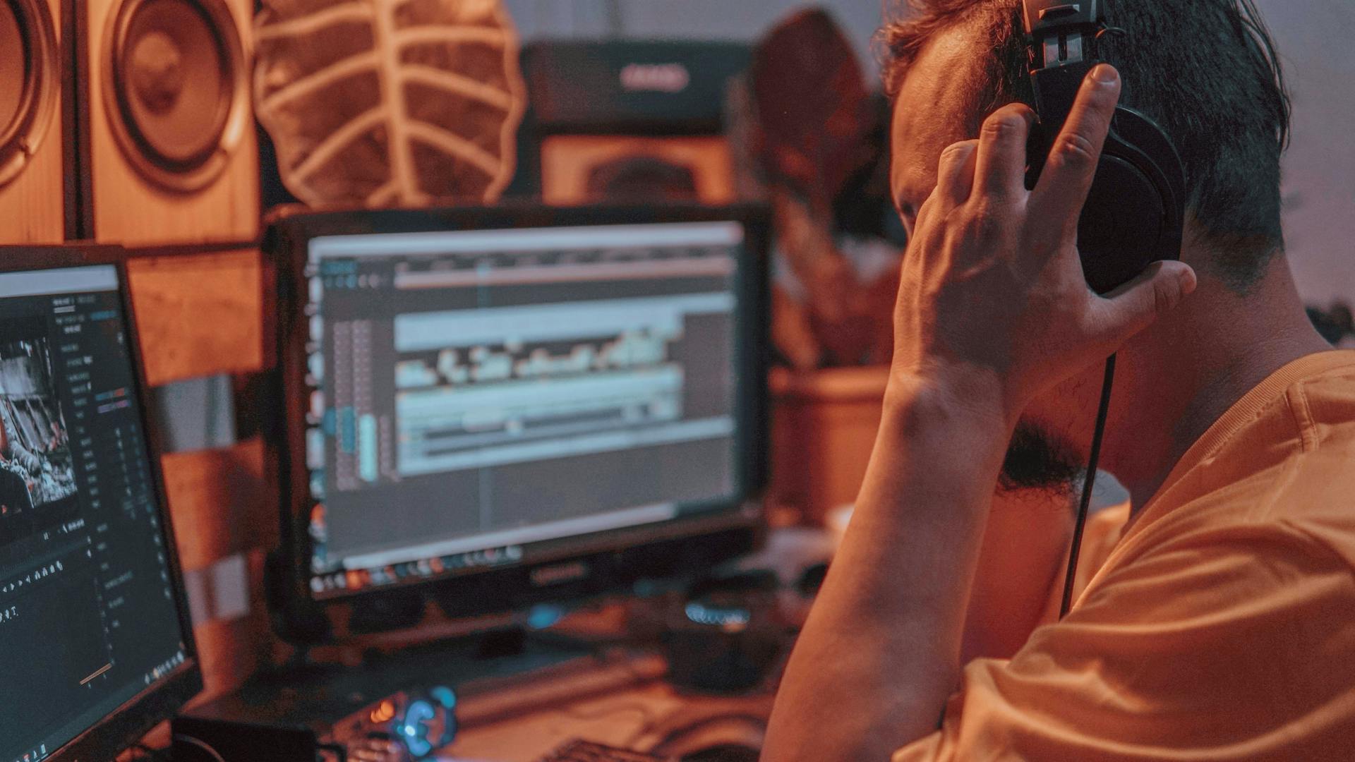 Close-up of an audio engineer editing sound on a computer in a recording studio.