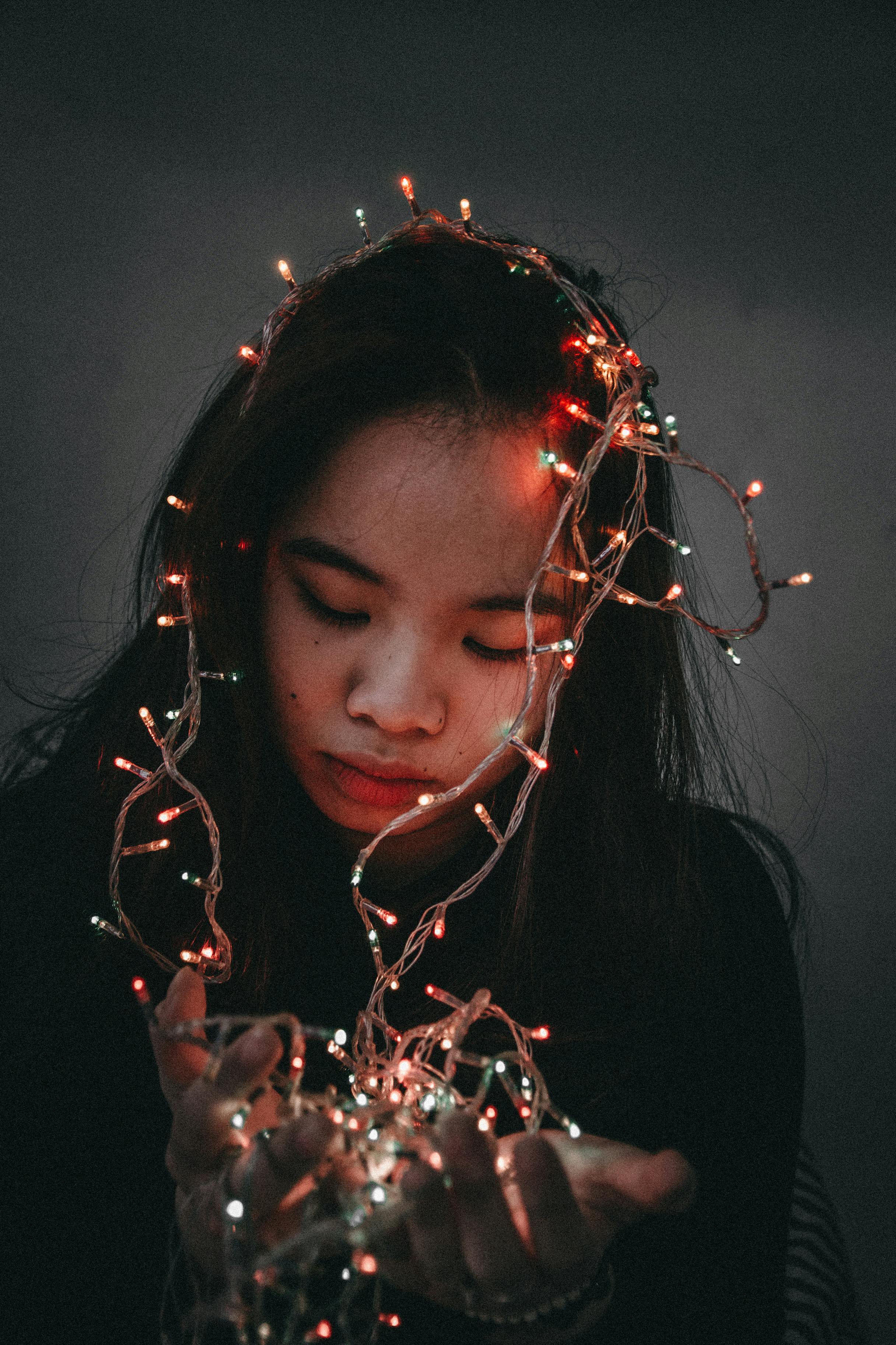 一位手持发光灯的女人肖像，营造出喜怒无常的氛围