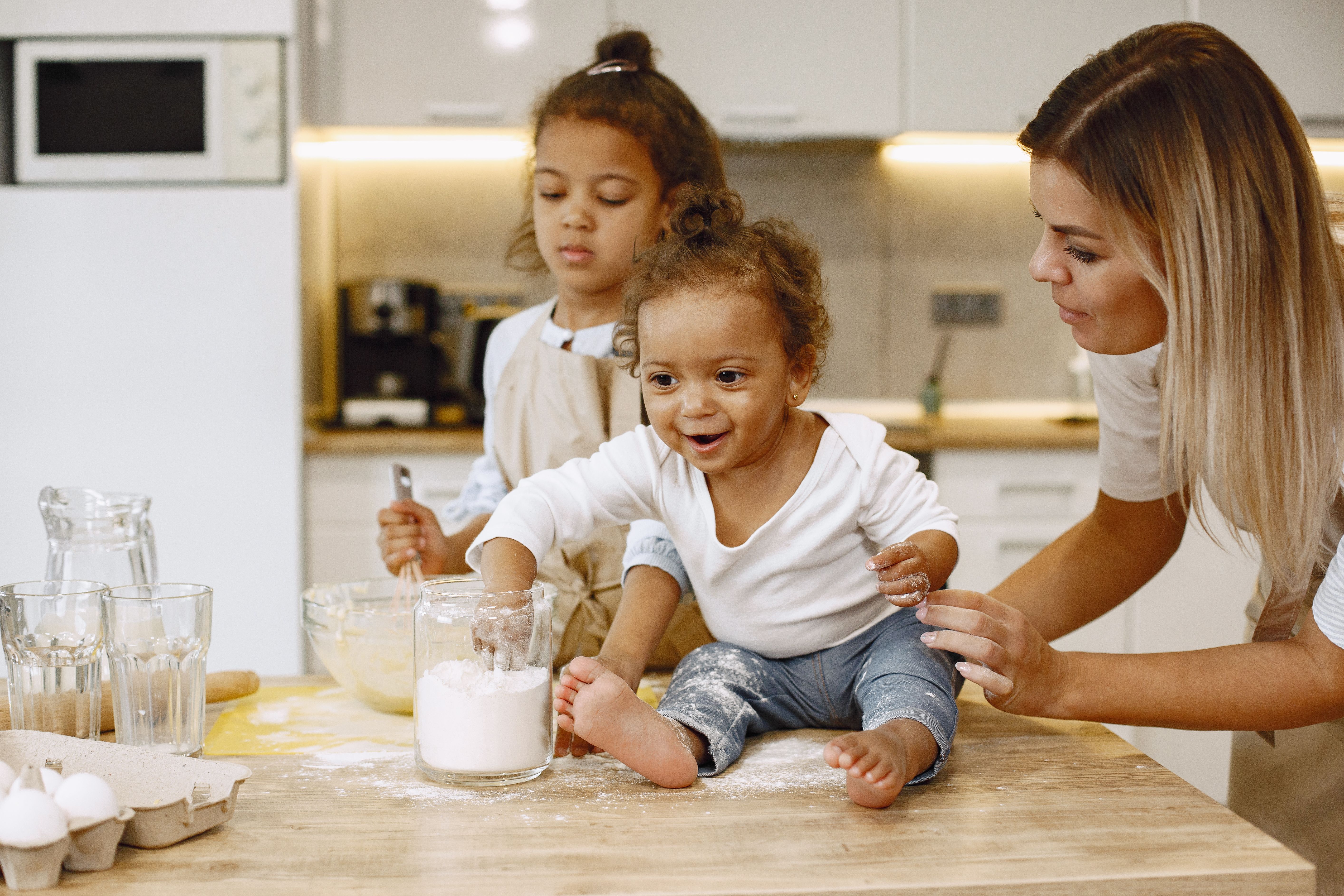 Mother and children enjoying a fun baking session in a modern kitchen.