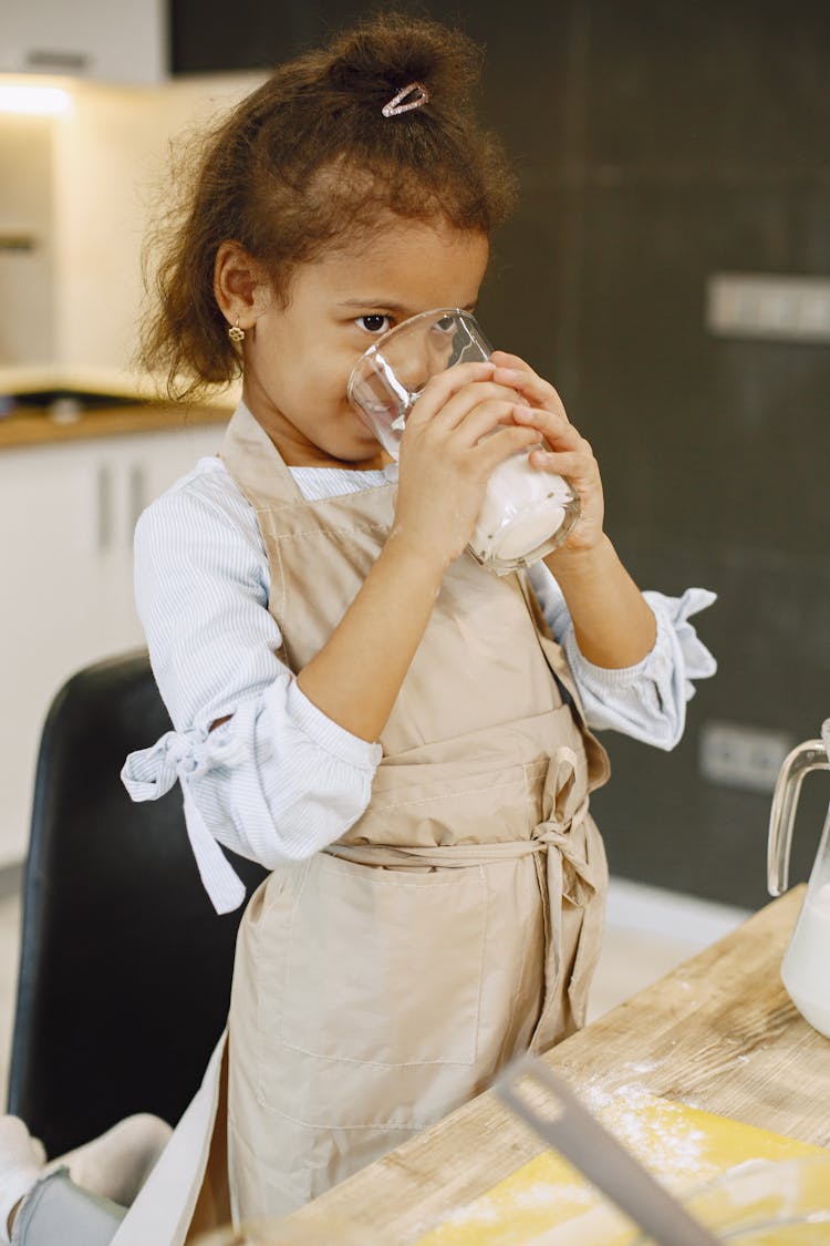 A Girl Drinking A Glass Of Milk