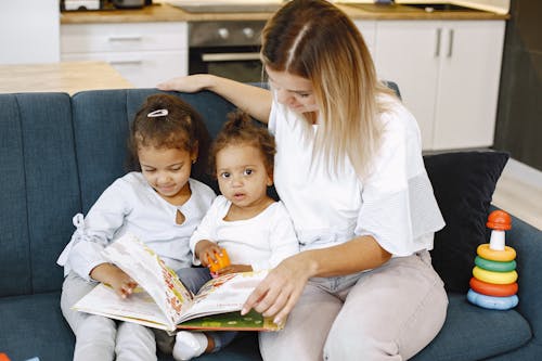 Two Girls and a Woman Reading a Book