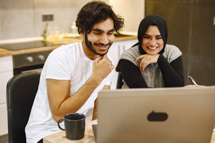 Man And Woman Looking At Laptop