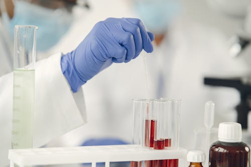 Person Holding a Pipette into a Test Tube