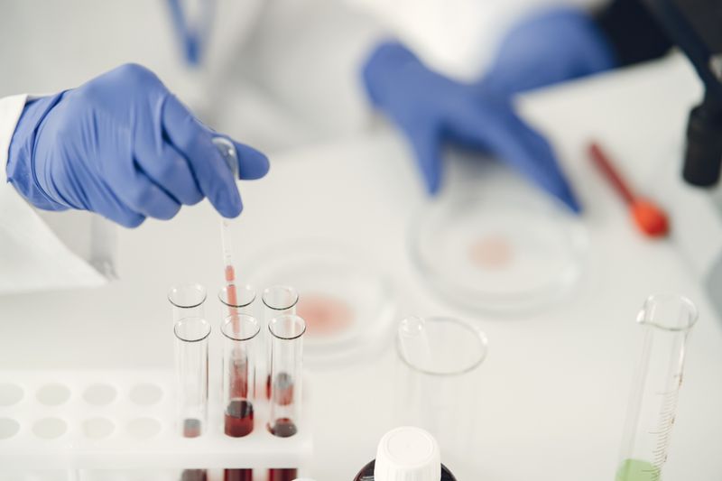 Chercheur prélevant un échantillon chimique à la pipette, illustrant la reconstitution du rétatrutide lyophilisé en laboratoire