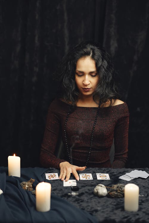 Free Woman in Brown Long Sleeve Holding Playing Cards Stock Photo