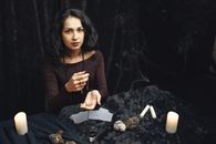 Woman in Black Long Sleeves Sitting Near Table with Playing Cards