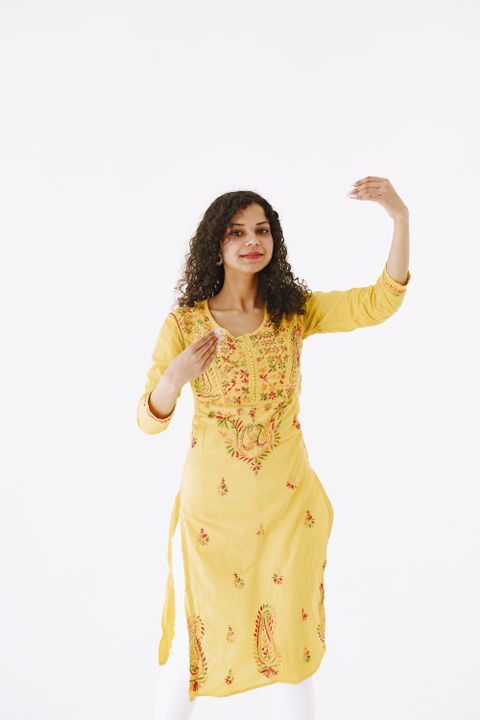 Woman in a yellow chikankari kurta on a white background