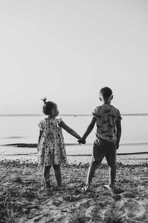 Young Kids Standing on the Beach while Holding Hands