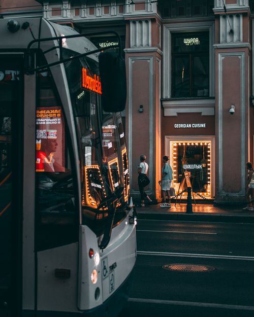 Free A city bus passes by a Georgian restaurant in Saint Petersburg at night. Stock Photo