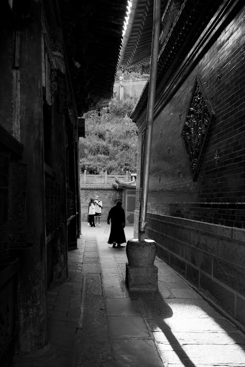 Free Grayscale Photo of a Person Walking in the Alley Stock Photo