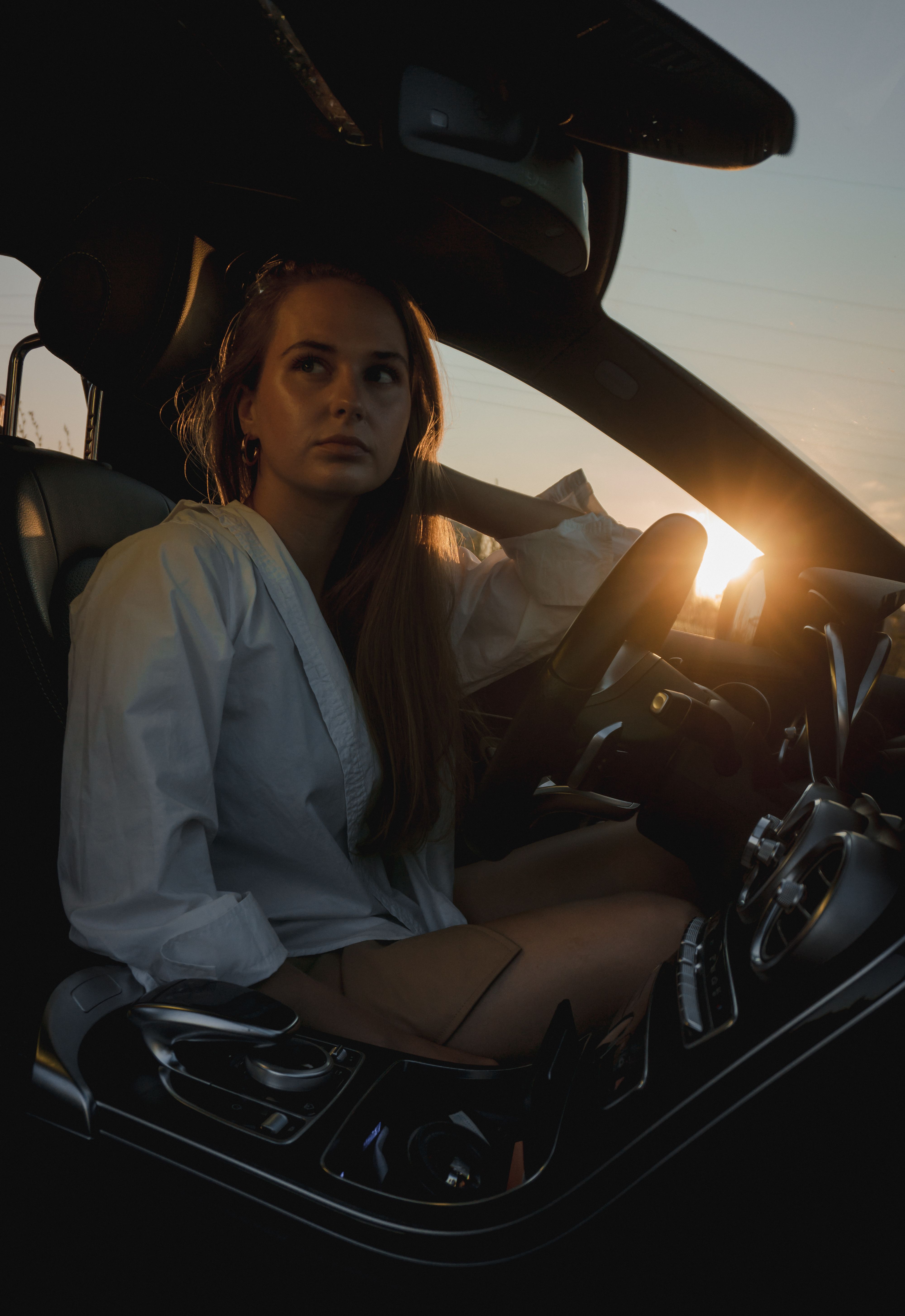 Woman in White Long Sleeve Shirt Driving a Car · Free Stock Photo
