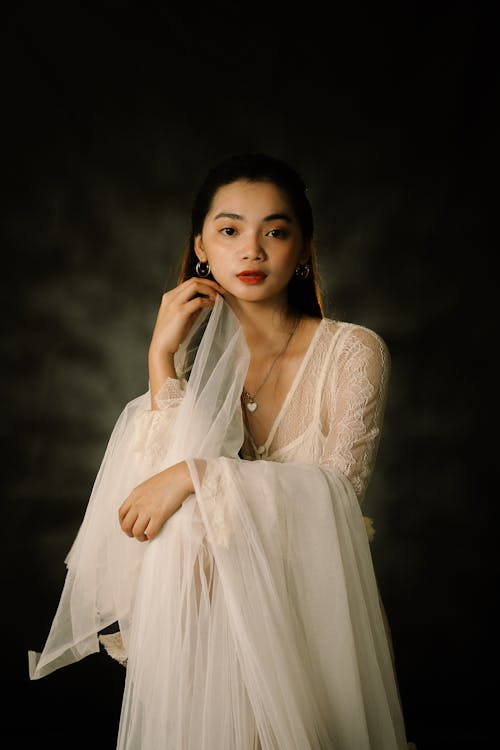 Woman in White Dress Touching Her Chin