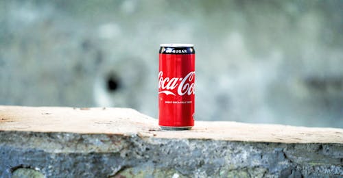gratis Coca Cola Kan Op Bruine Betonnen Ondergrond Stockfoto