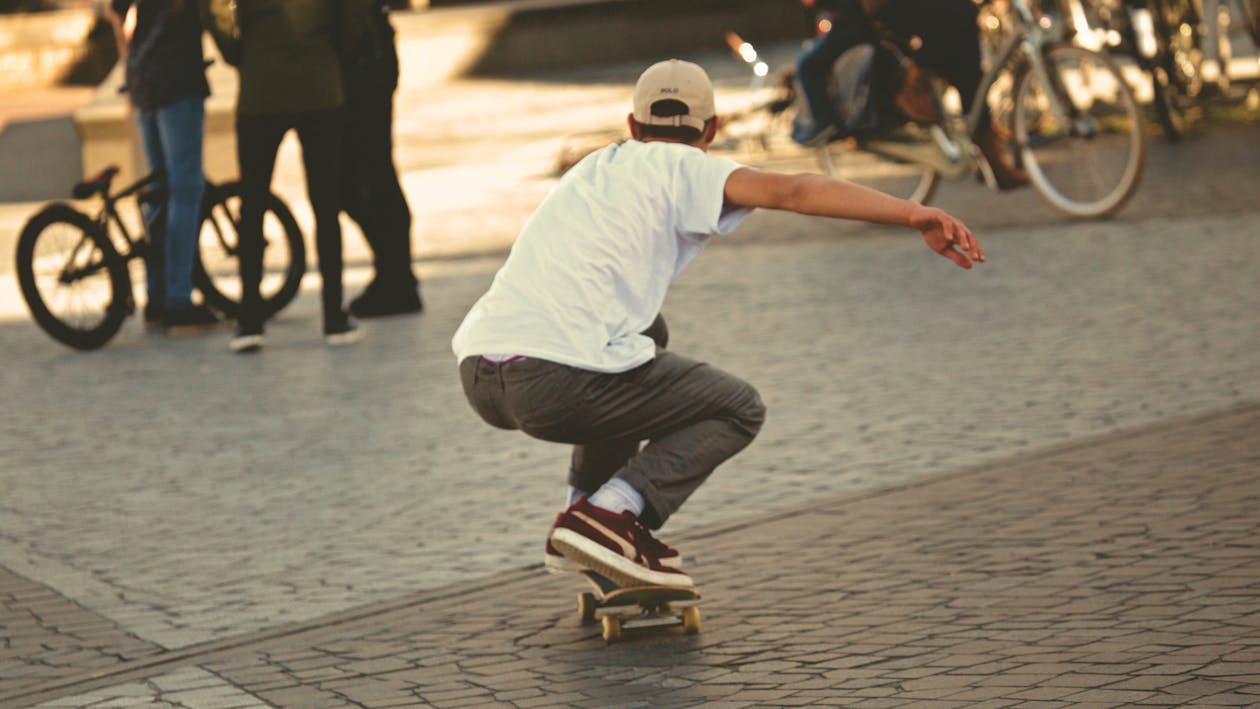 Gratis Uomo In Camicia Bianca E Jeans Marroni Equitazione Skateboard Foto a disposizione