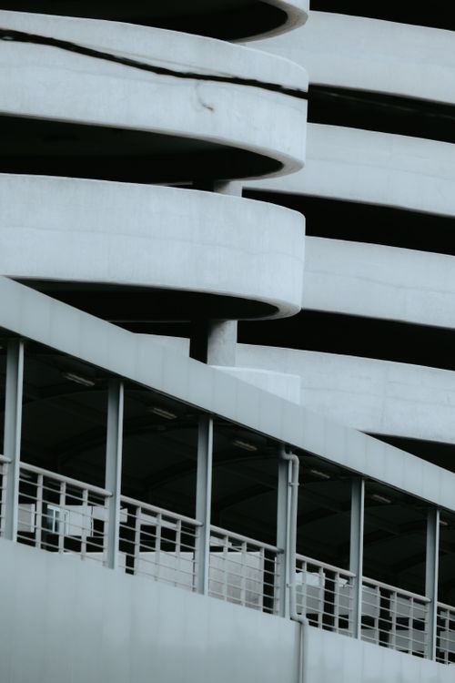 Free Abstract view of a modern concrete parking structure with spiral ramps. Stock Photo