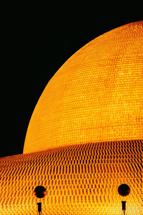 Free A stunning illuminated gold temple dome against a dark night sky. Stock Photo