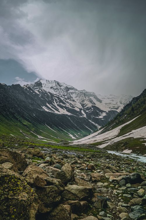 Free A breathtaking view of a snow-capped mountain with a rocky valley. Captures nature's beauty. Stock Photo