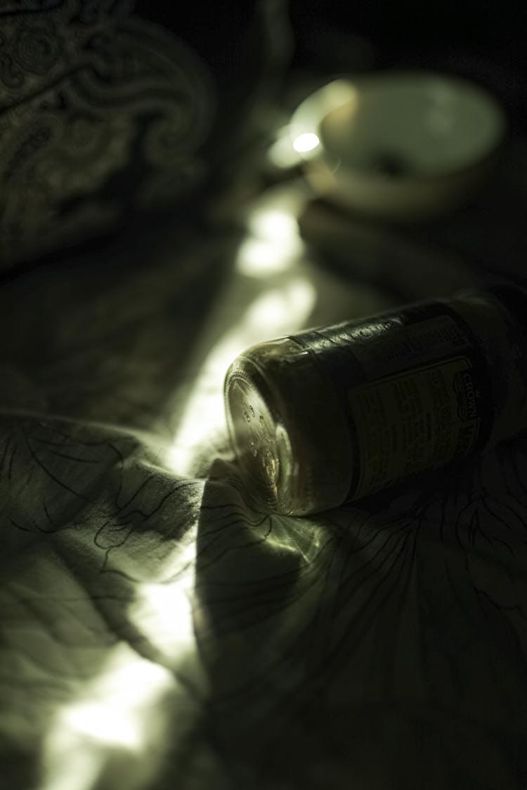 Bottle On Textile In Dark Room