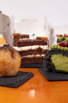 Indulge in assorted cakes and pastries elegantly arranged on slate boards, promising a sweet culinary delight.