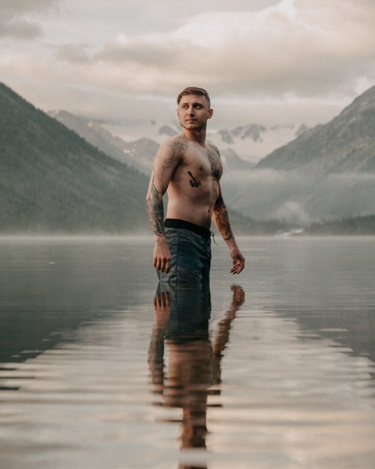 A Shirtless Man Standing On Water