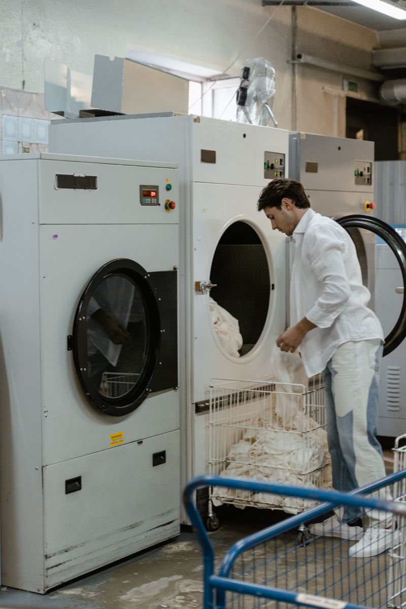 Attendant loading laundry into a commercial washer