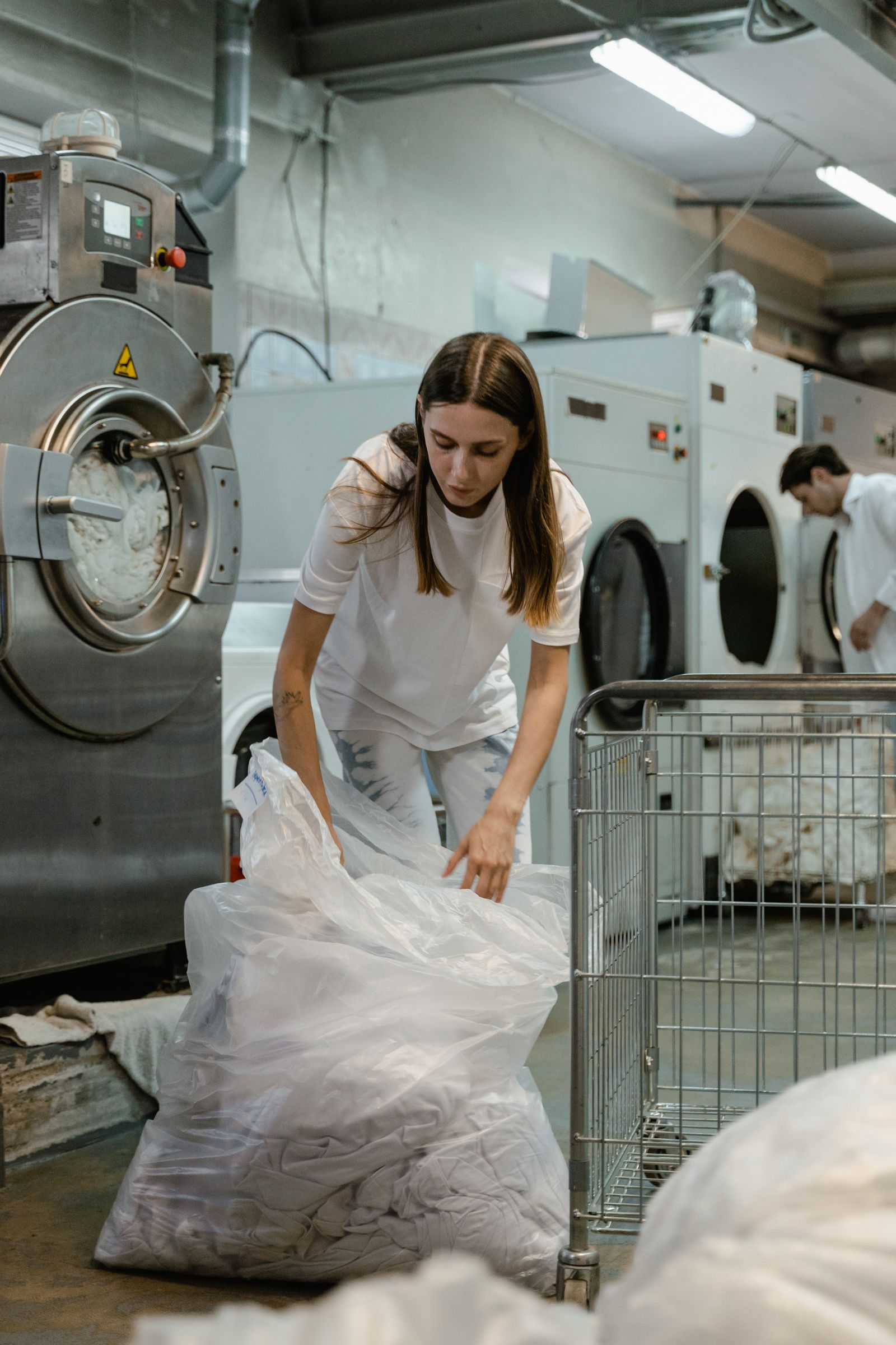 Professional laundry worker handling freshly cleaned garments