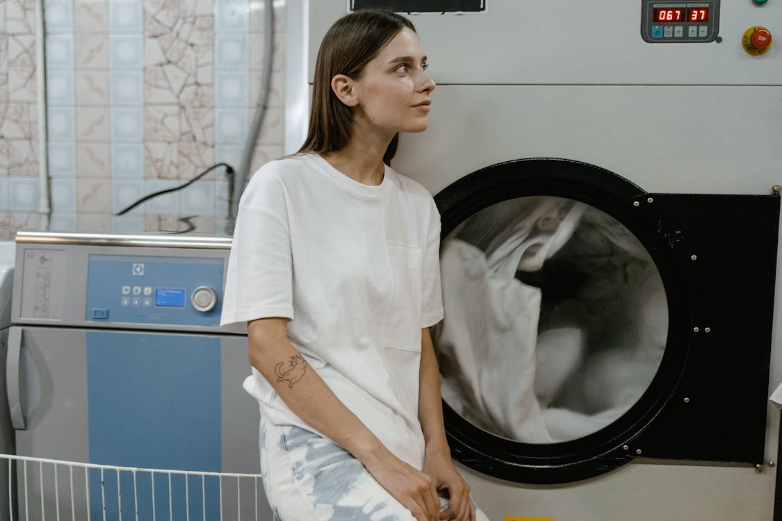 Free A Woman in White Shirt Leaning on the Machine Stock Photo