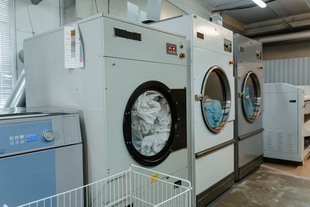 Interior view of laundry machines in a facility with linens being washed
