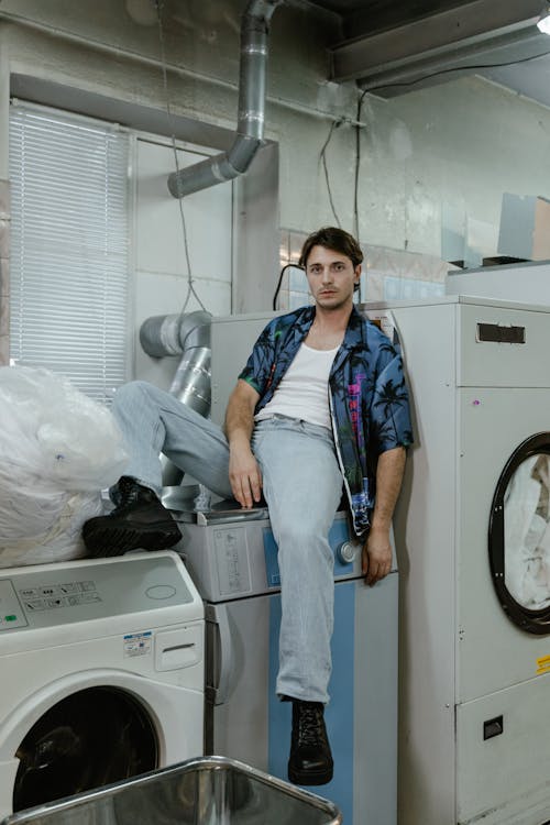 Free A Man Sitting on a Washing Machine Stock Photo