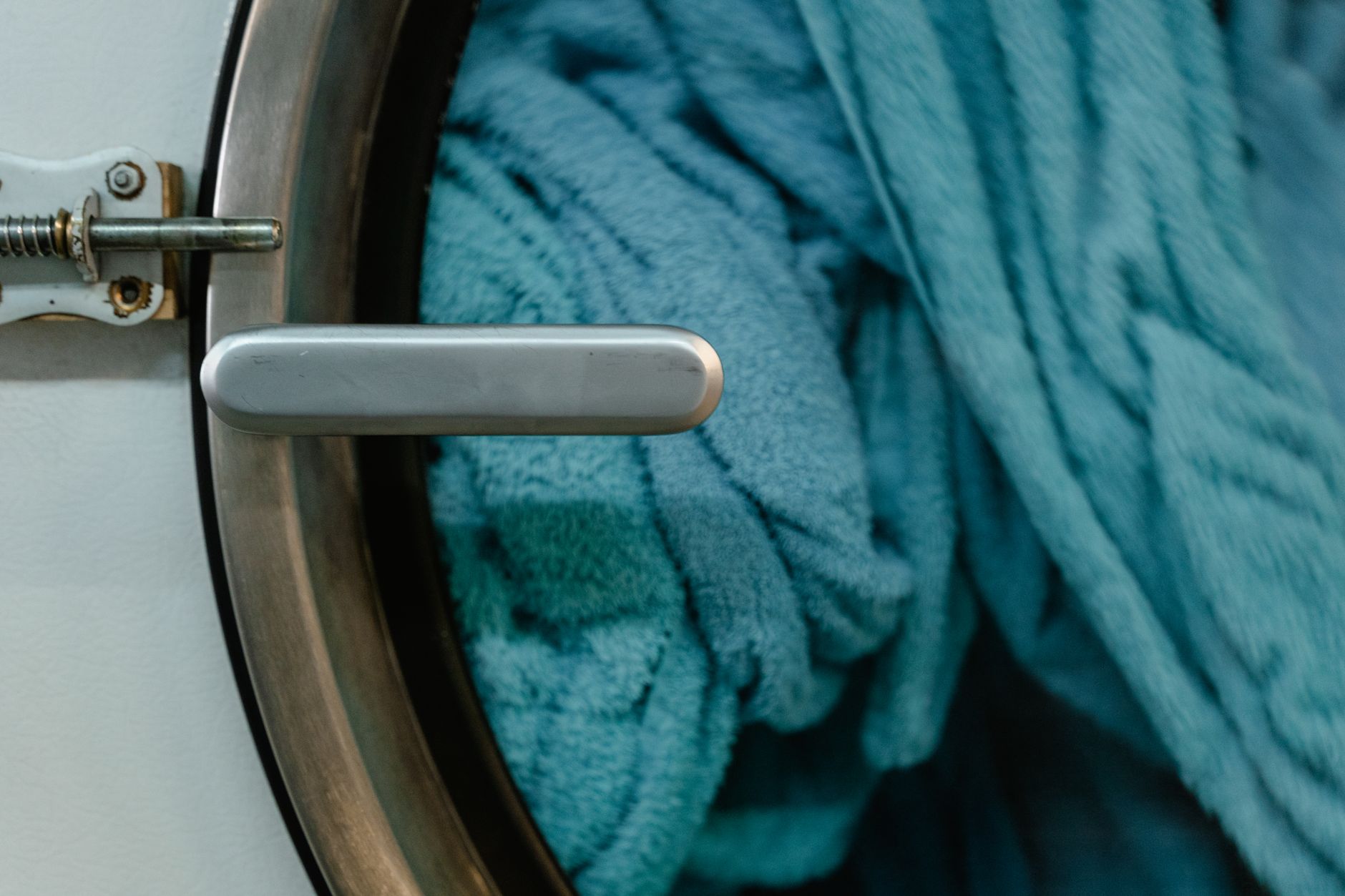 Cold water rinsing a fresh breast milk stain on white cotton fabric