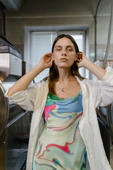 Portrait of a fashionable young woman indoors wearing a colorful dress and white shirt