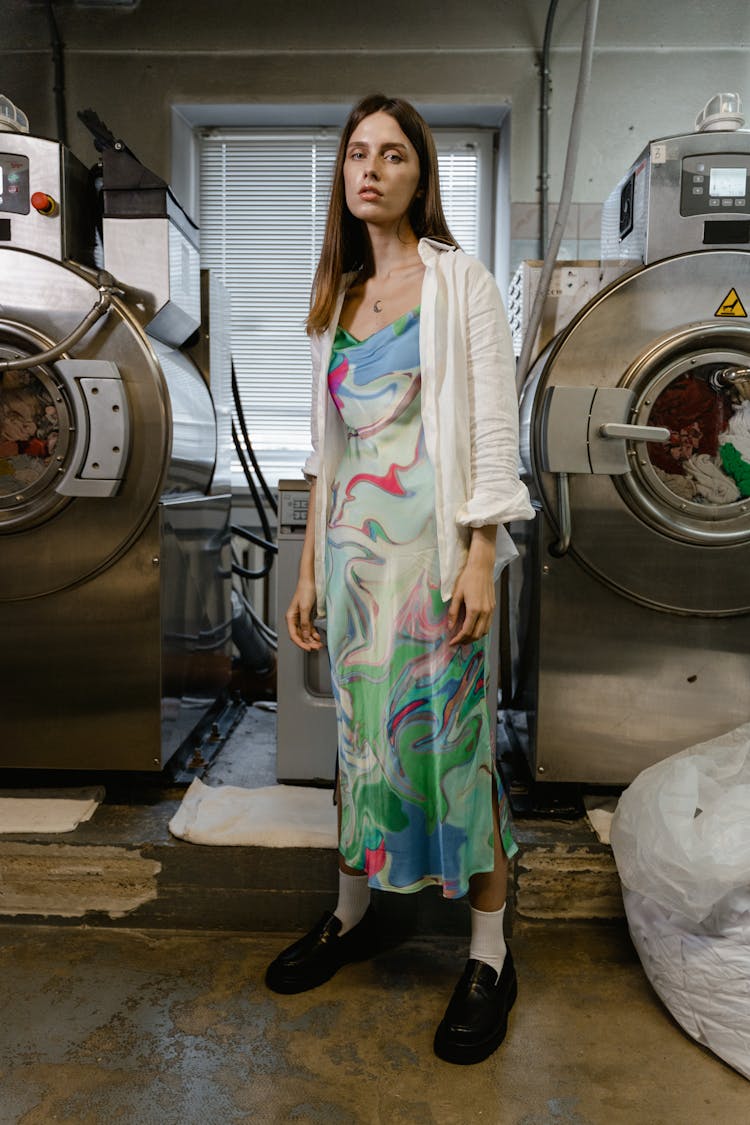 Woman In White Green And Pink Floral Dress Standing Beside Front Load Washing Machine