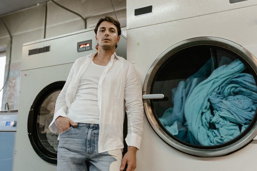 Foldly specialist leaning on an industrial washing machine