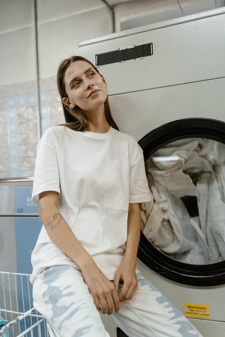 A Woman Sitting Beside The Laundromat