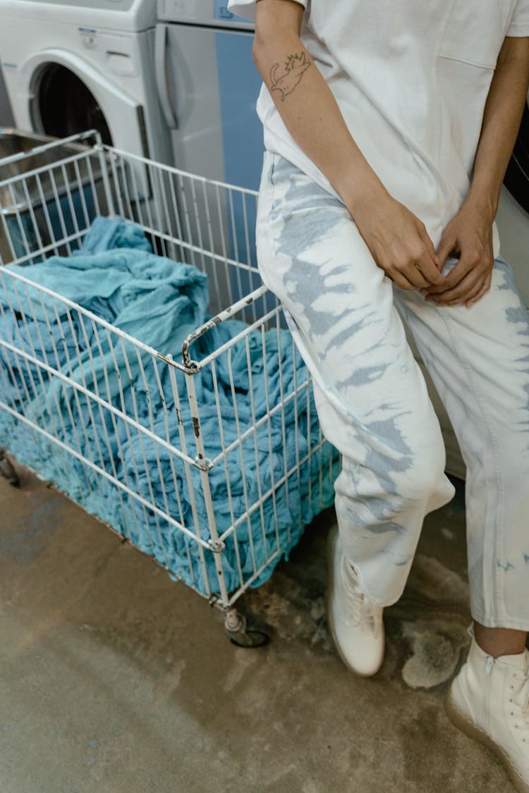 A Person Sitting On A Laundry Push Cart