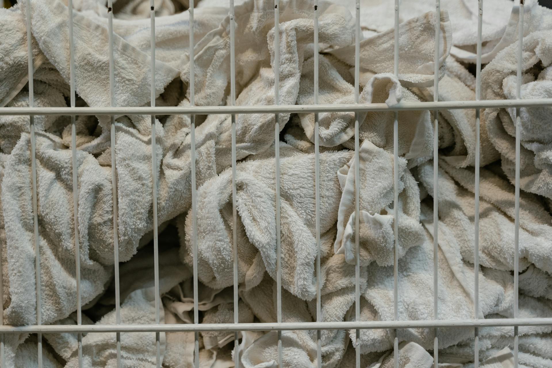 White towels neatly folded in a basket, perfect for household or cleaning themes.