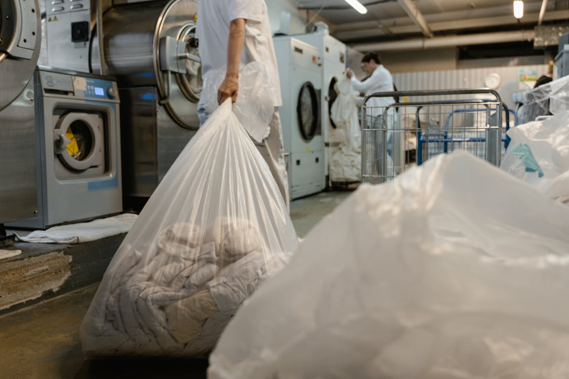 Free A Person Holding a Plastic Bag with Laundry Stock Photo
