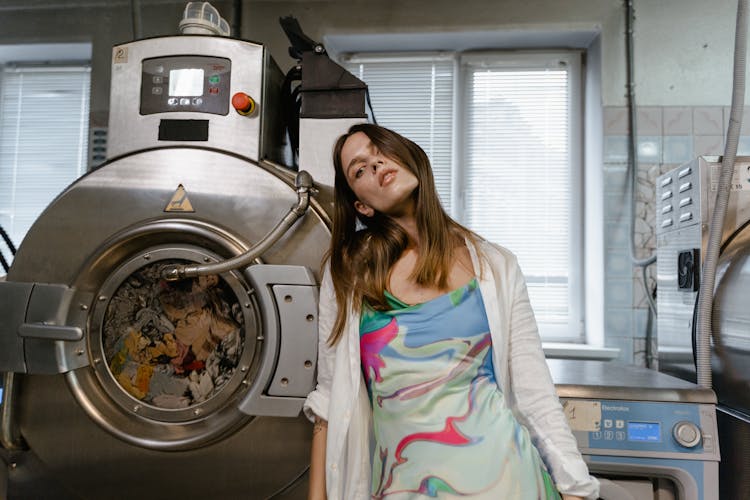 A Woman Standing Beside The Laundry Machine